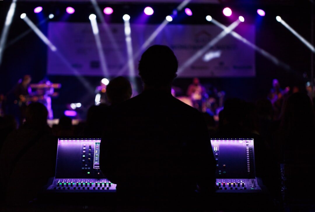 Producer reviewing footage on a laptop backstage at an event